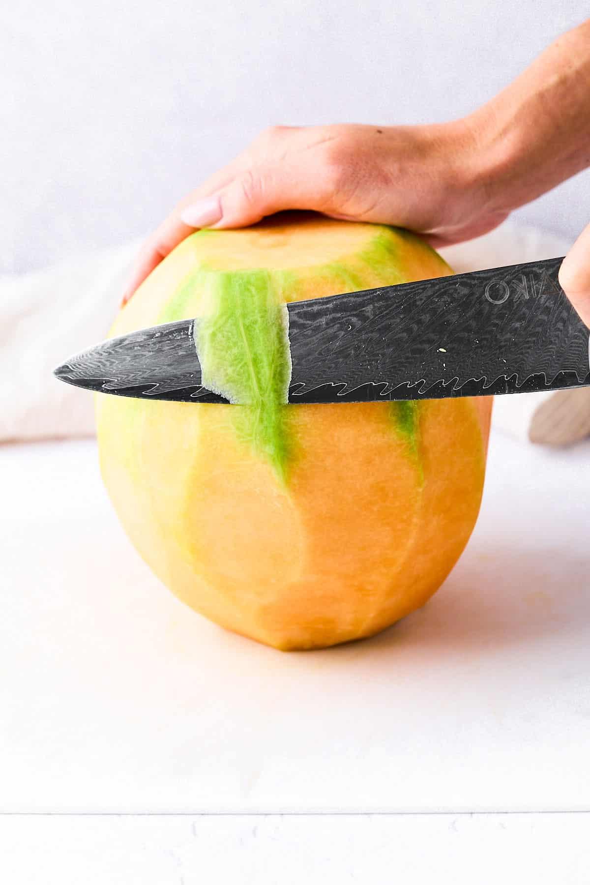 Wie man eine Cantaloupe schneidet (Ohne einen Finger zu verlieren!) 5 Die Schale der Kantalupemelone abschneiden.