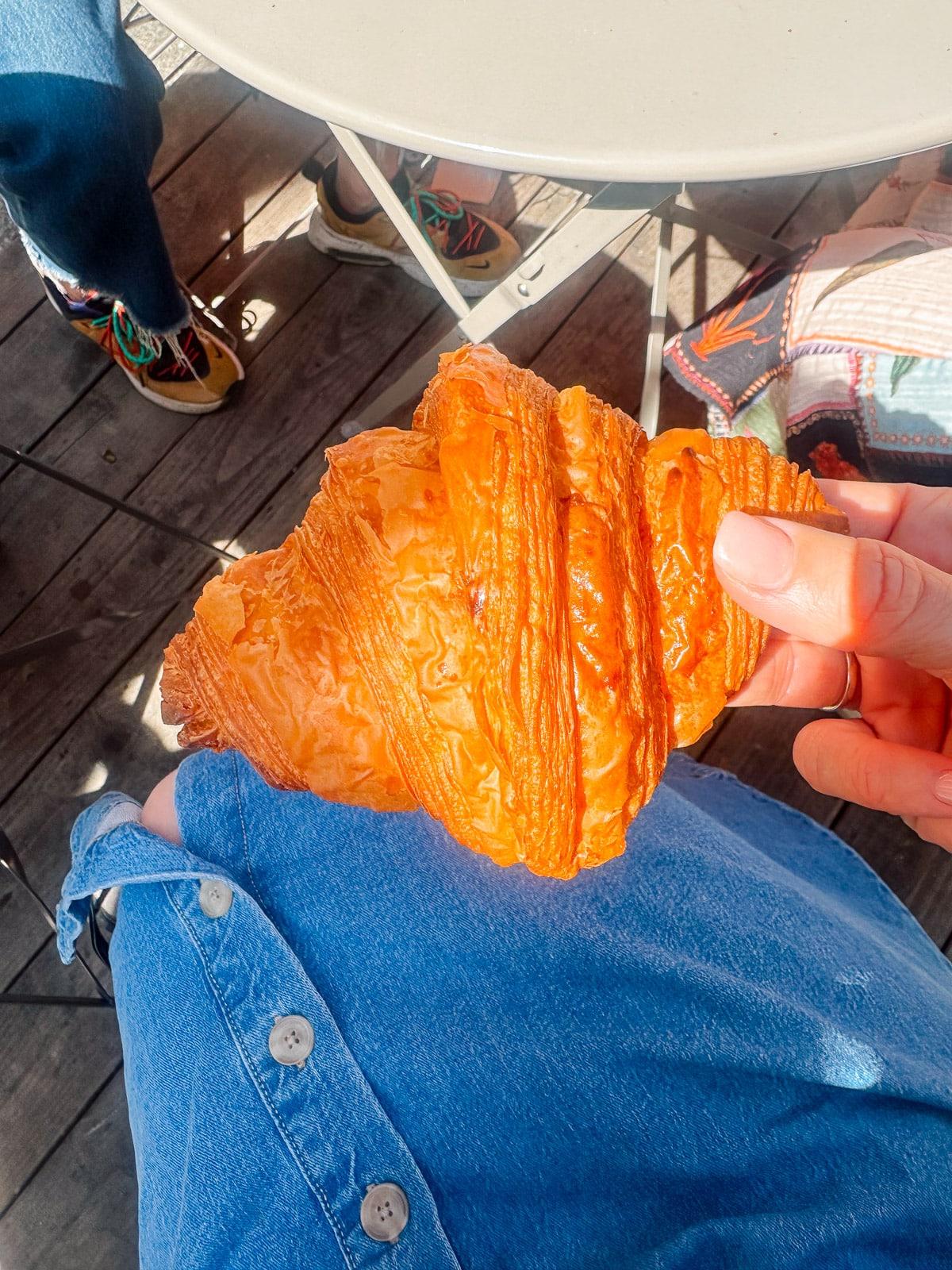 Ein Feinschmecker in Frankreich 5 Verschiedene französische Backwaren in einer Auslage, darunter goldbraune Croissants und bunte Macarons.