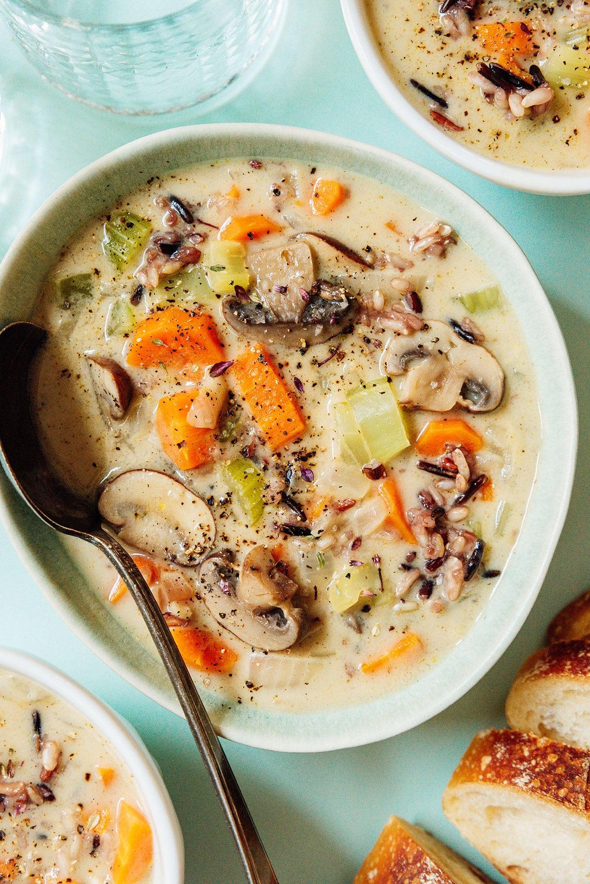 Cremige Vegane Wildreissuppe 5 Eine Schüssel Wildreissuppe mit einem Löffel.