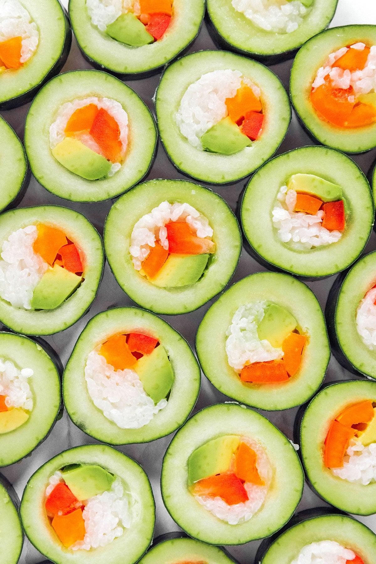Gurken Grundlagen 5 Nahaufnahme von gefülltem Gurken-Sushi mit Reis, Karotten und Avocado