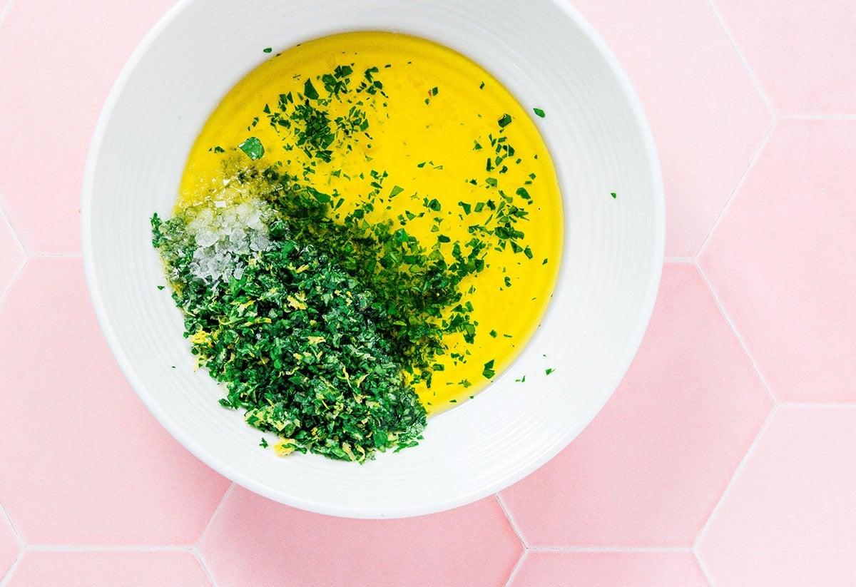 Zitronige Gremolata Pasta (Fertig in 15 Minuten) 5 Eine weiße Schüssel gefüllt mit Olivenöl, Gremolata, Salz und Zitronensaft