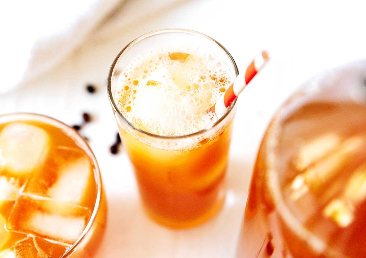 Kaffee-Kombucha 5 Kaffee Kombucha in einem Glas mit Eis und Strohhalm