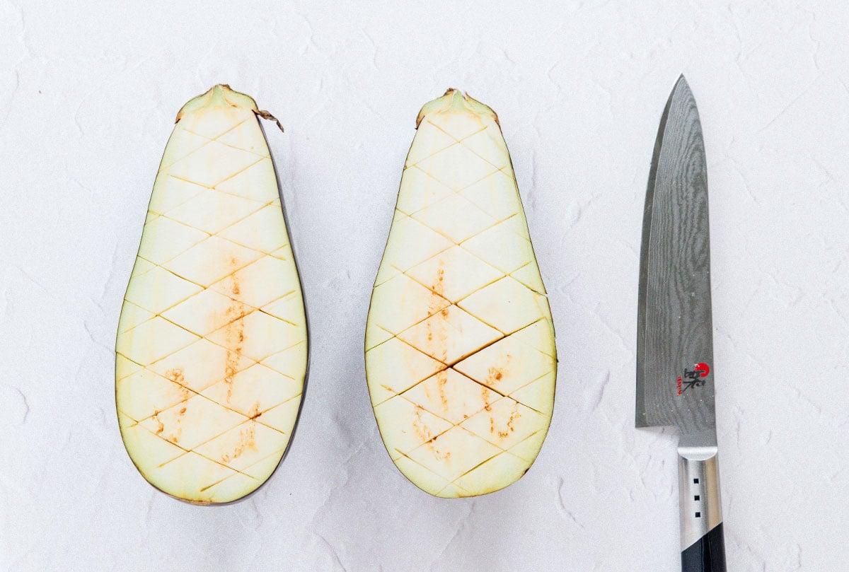 Geröstete Aubergine mit Feta-Minz-Soße 5 Längs halbierte Aubergine mit kreuzweise eingeritztem Fruchtfleisch.