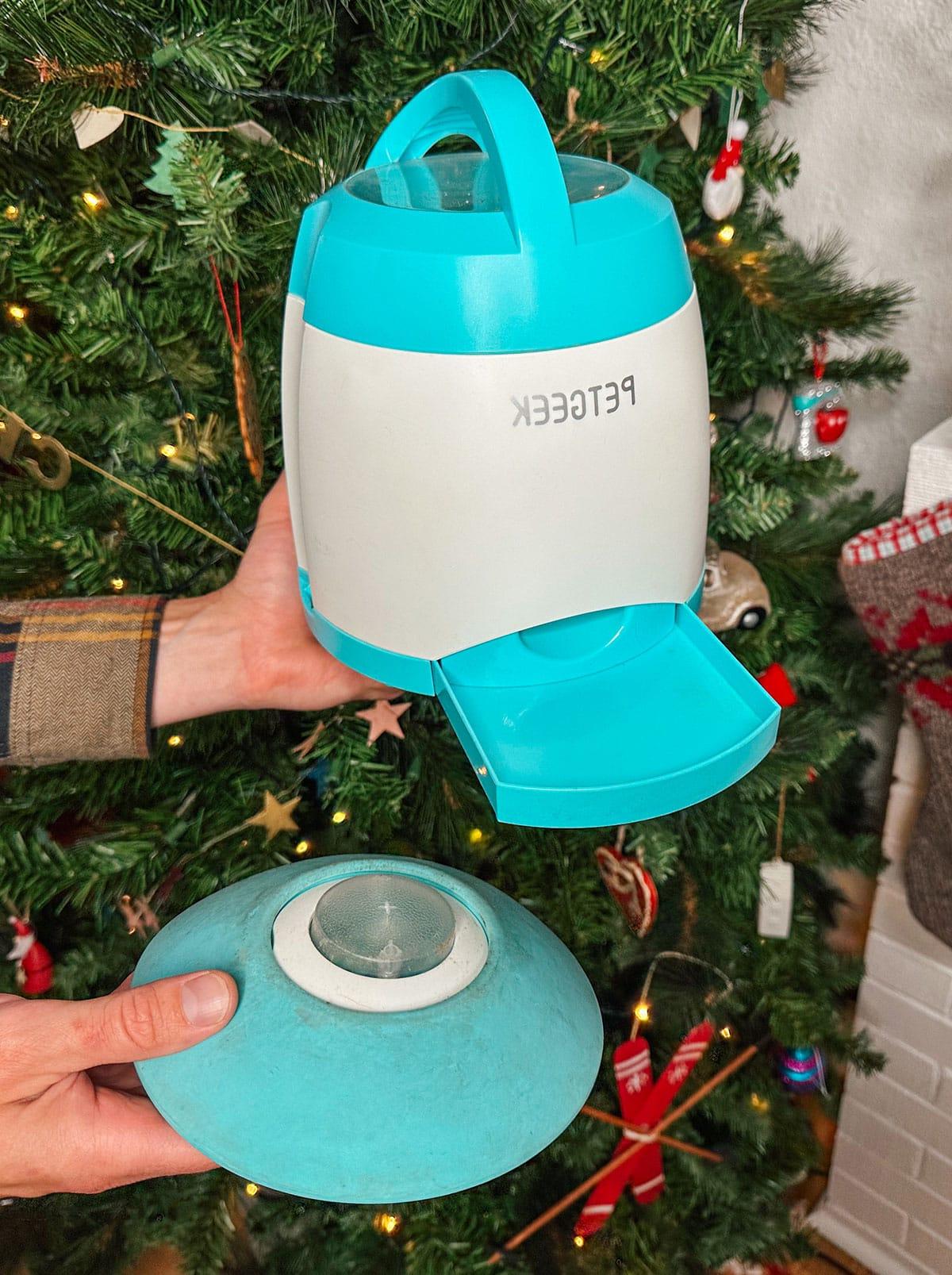 Ein Pet Geek Leckerli-Spender als Geschenk vor einem Weihnachtsbaum.