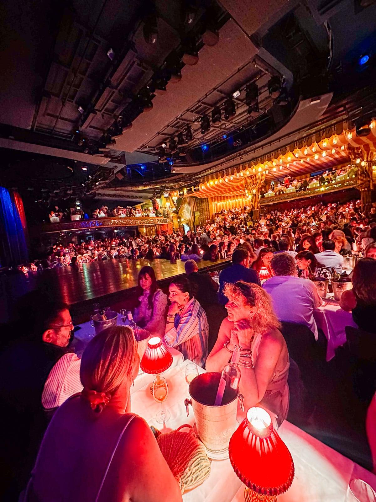 Ein Feinschmecker in Frankreich 49 Nahaufnahme der Show im Moulin Rouge mit Tänzerinnen in extravaganten Kostümen.
