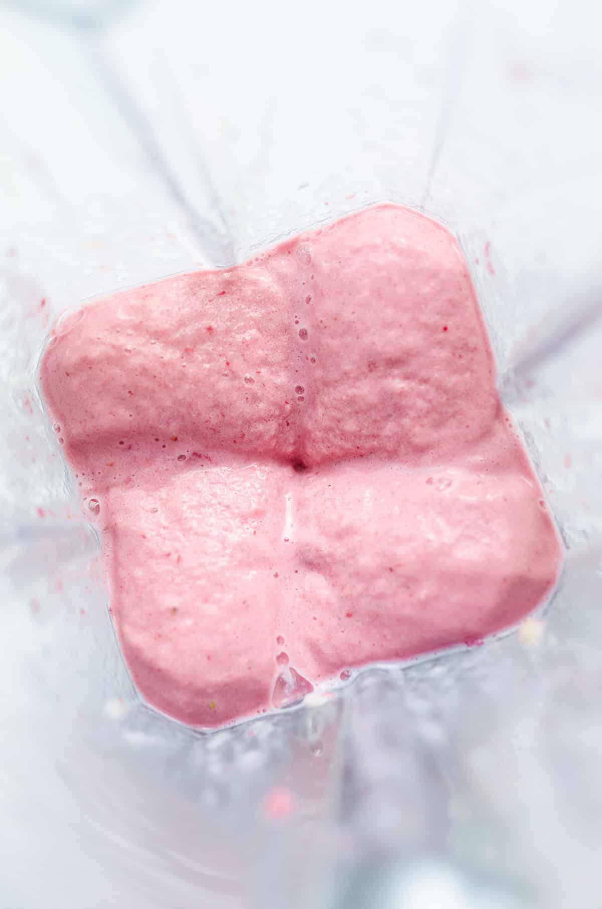 Erdbeer-Bananen-Smoothie (3 Zutaten) 6 Gemixter roter Smoothie in einem Mixer.