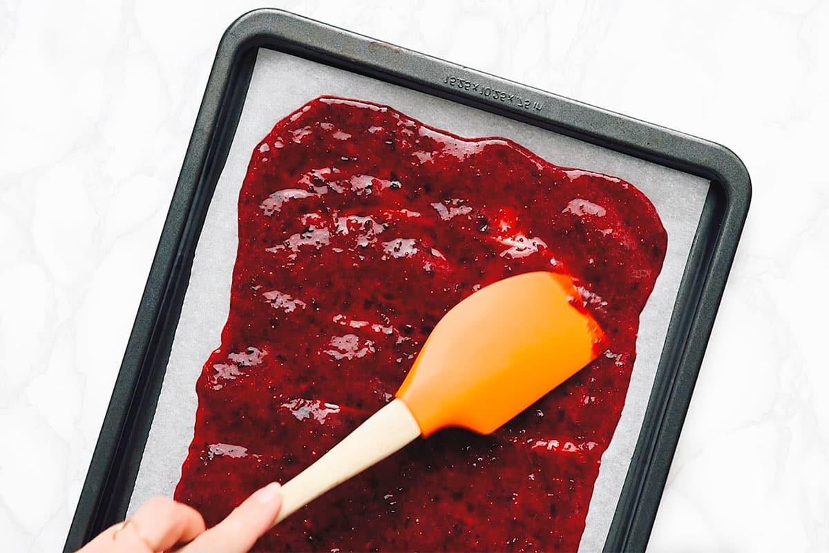 Gesunde selbstgemachte Fruchtleder 6 Fruchtpüree auf einem Backblech ausbreiten.