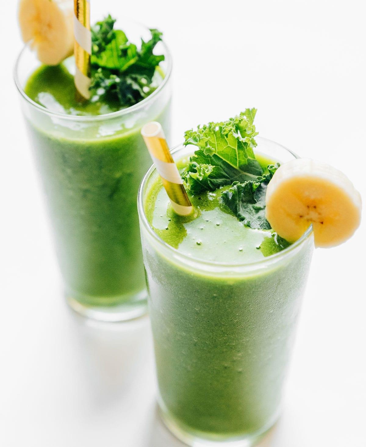 Vier-Zutaten-Ananas-Grünkohl-Smoothie 6 Grünkohl-Ananas-Smoothie in einem Glas mit Papierstrohhalm.