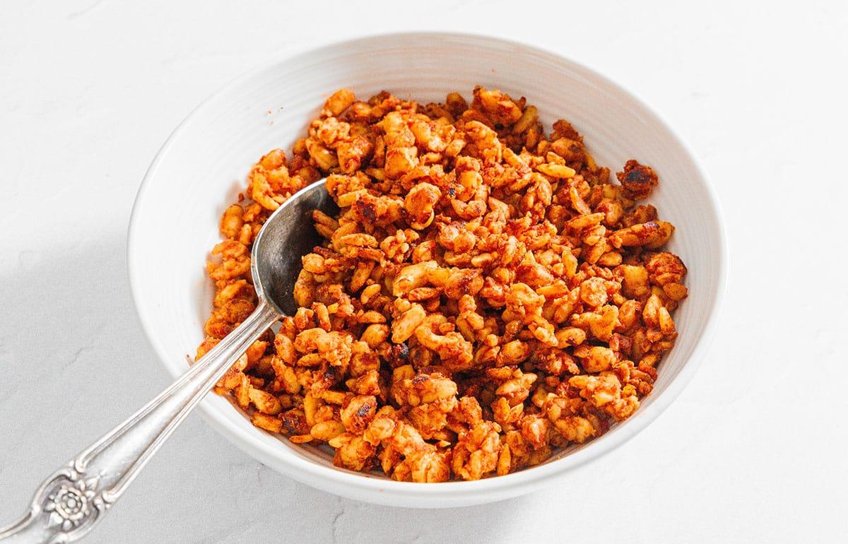 Tempeh Taco Fleisch 6 Eine Schüssel mit veganem Tempeh-Taco-Fleisch und einem Servierlöffel, detailliert und appetitlich angerichtet.