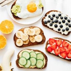 **10 Arten, Hummus zu essen (+ Rezepte!)** 6 Ideen für gesunde Toast-Beläge auf weißem Hintergrund.