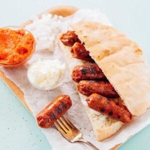 Vegetarische Cevapcici (Kroatisches Cevapi-Sandwich-Rezept) 7 Vegetarische Cevapi auf einem Teller mit Ajvar und Kajmak.