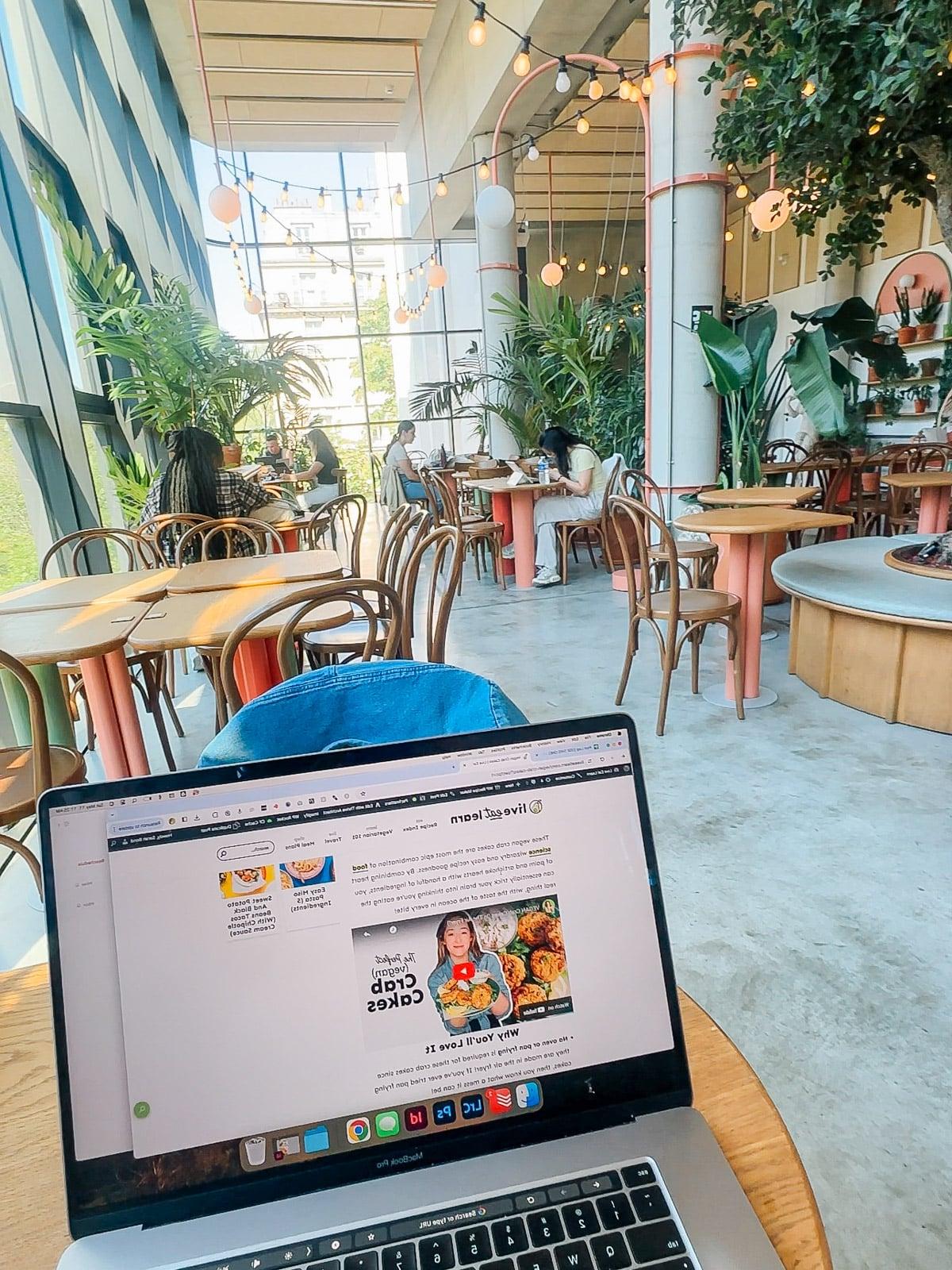 Ein Feinschmecker in Frankreich 7 Ein gemütlicher Coworking Space in einem modernen Hostel, mit stilvollen Möbeln und Pflanzen.