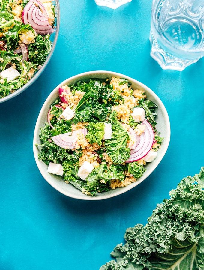 Grünkohl vs. Spinat: Was ist besser? (Mit Fotos!) 7 Quinoa-Grünkohl-Salat in einer Schüssel auf blauem Hintergrund