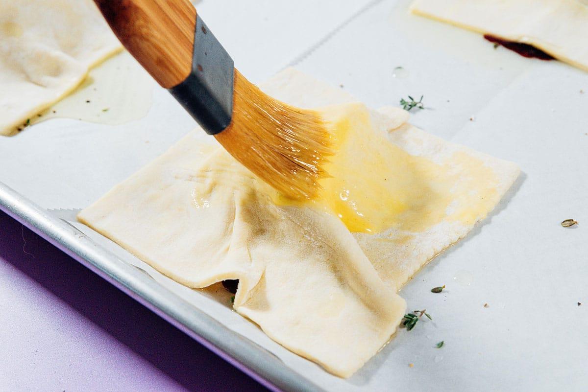 **Gestürzte Zwiebeltarte mit Brie** 7 Teig mit Ei bestreichen.