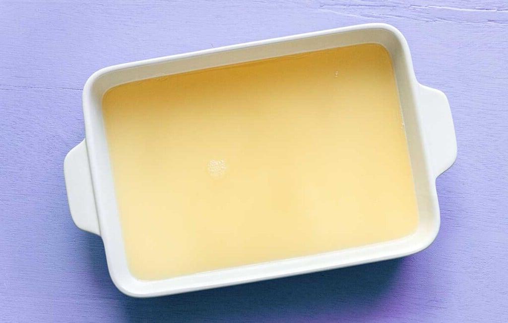 Einfache Lavendel-Zitronenlimonade (Saft oder Slush!) 7 Eine flache Auflaufform, gefüllt mit frisch zubereiteter Lavendel-Zitronenlimonade, steht im Gefrierschrank bereit zum Einfrieren.