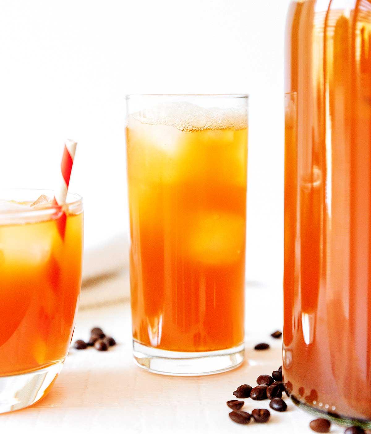 Kaffee-Kombucha 7 Kaffee Kombucha in einem Glas mit Eis und Strohhalm