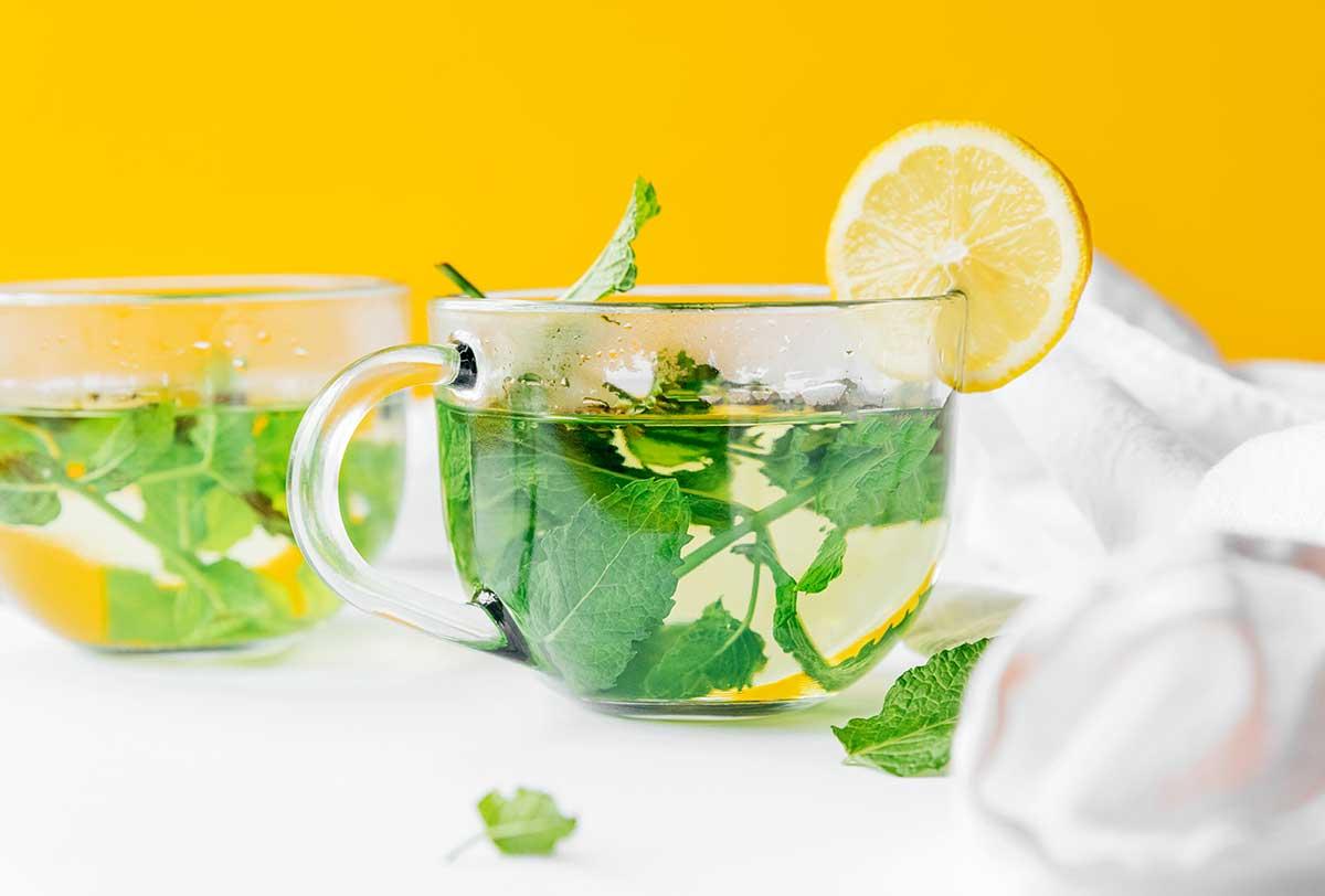 Frischer Minztee in einem klaren Glas mit einer Zitronenscheibe, bereit zum Genuss