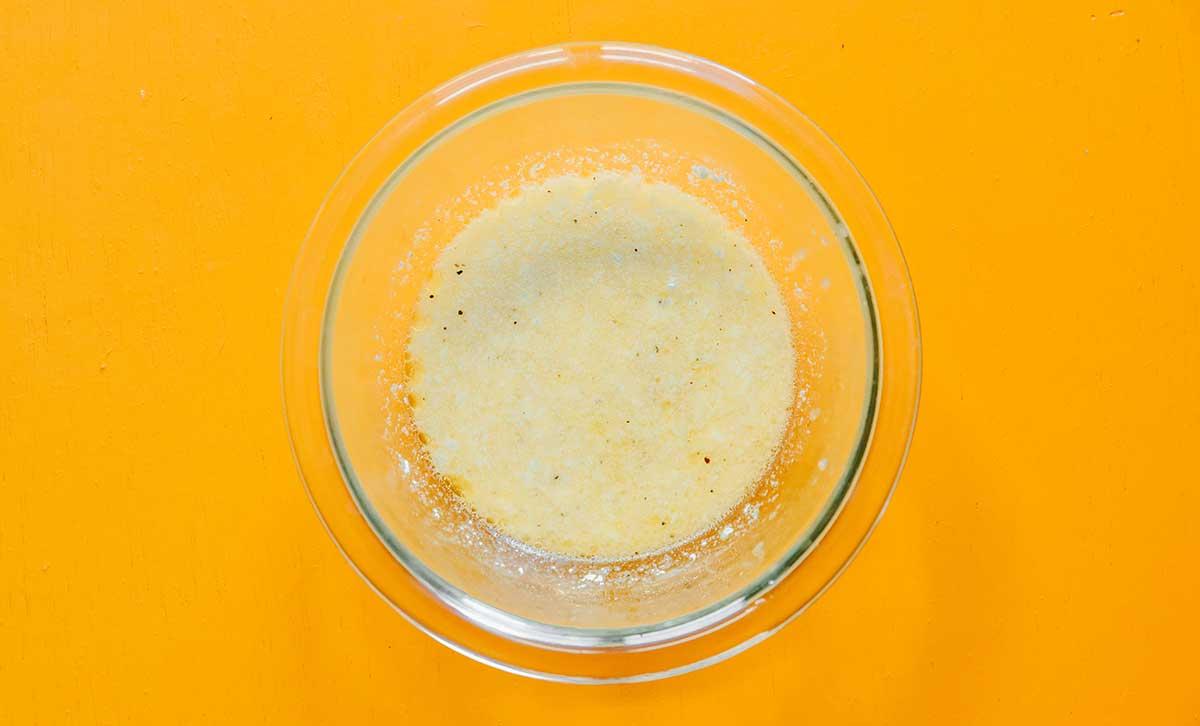 Geröstete Gemüse-Getreide-Bowls 7 Eine durchsichtige Glasschale, gefüllt mit Zutaten für Olivenöl- und Zitronensaft-Dressing.