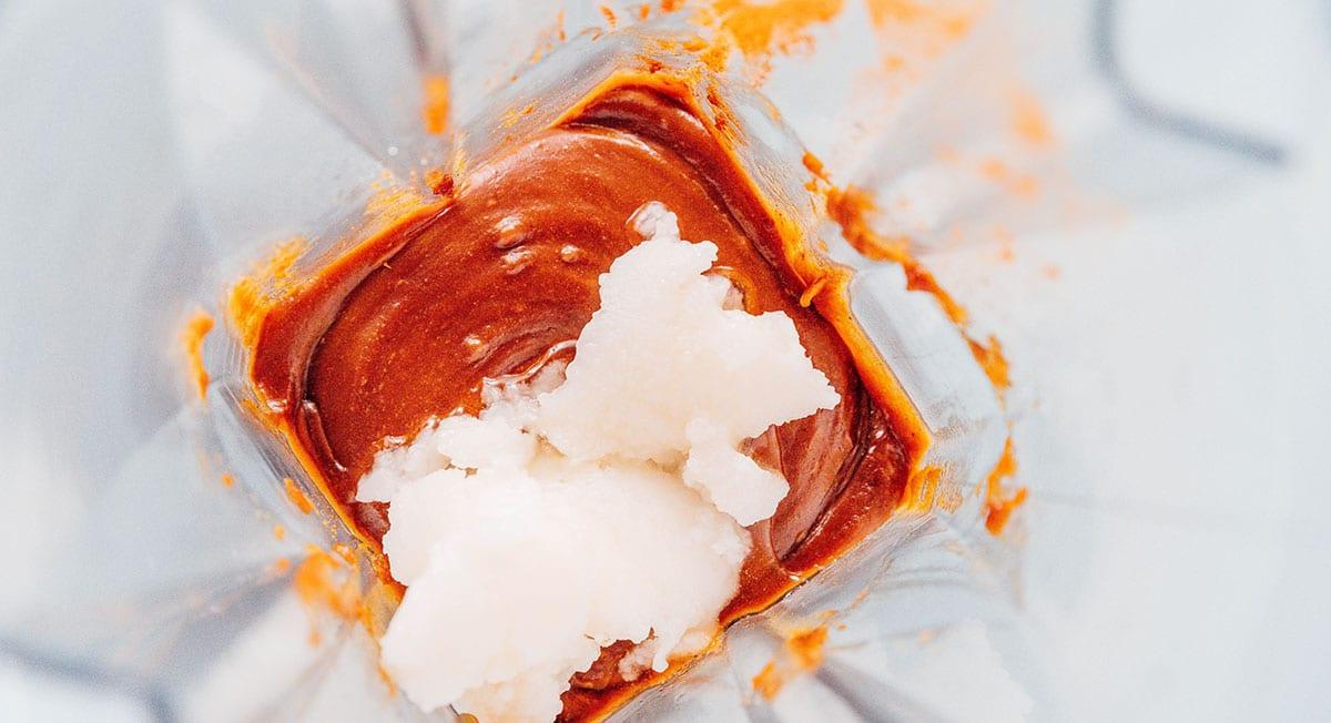 Wie man Spekulatius-Kekscreme herstellt 8 Keksbutter mit hinzugefügtem Kokosöl im Mixer, bereit zum Mixen.