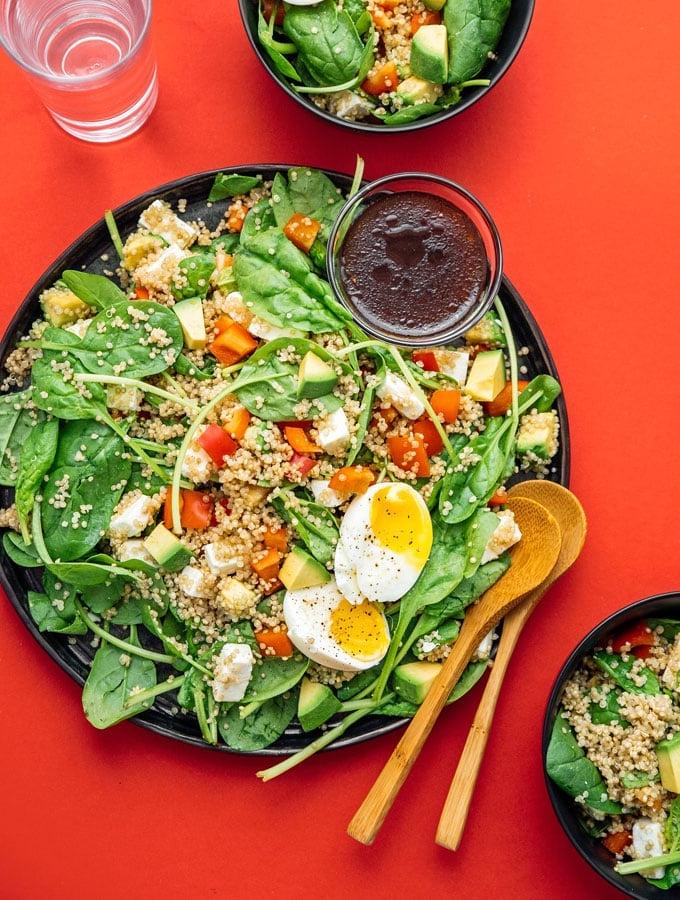 Grünkohl vs. Spinat: Was ist besser? (Mit Fotos!) 8 Mediterraner Quinoa-Salat auf einem Teller mit Servierlöffeln