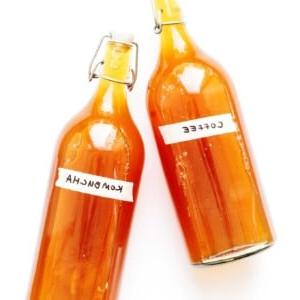 Kaffee-Kombucha 8 Kaffee Kombucha in Fermentationsflaschen auf weißem Hintergrund