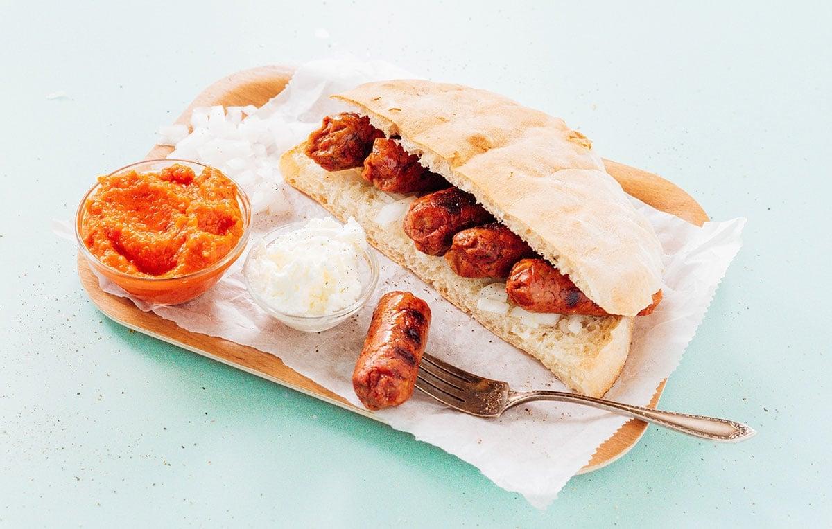 Vegetarische Cevapi auf einem Teller mit Ajvar und Kajmak.