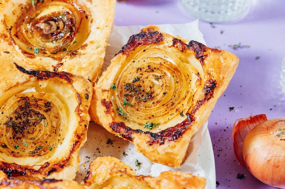 **Gestürzte Zwiebeltarte mit Brie** 9 Zwiebeltarte auf einem Teller.