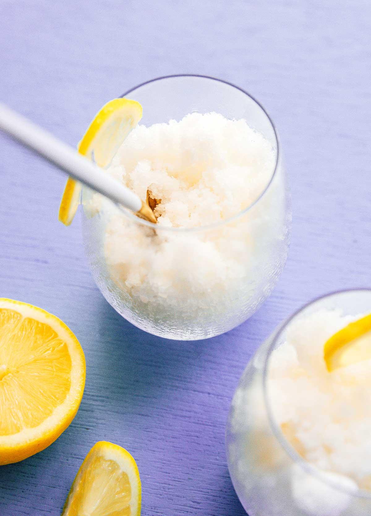 Einfache Lavendel-Zitronenlimonade (Saft oder Slush!) 9 Ein Glas, gefüllt mit eisigem Lavendel-Zitronenlimonaden-Slushie, garniert mit frischen Zitronenscheiben und einem Strohhalm, bereit zum Genießen.