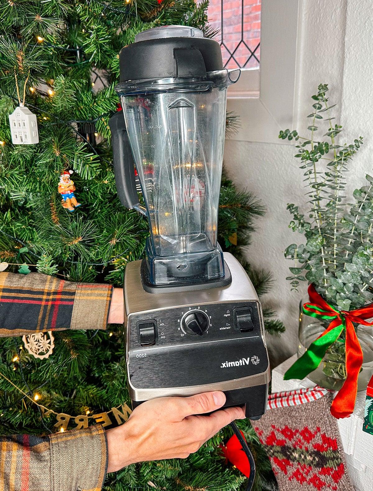 Ein Vitamix Hochleistungsmixer als Geschenk vor einem Weihnachtsbaum.