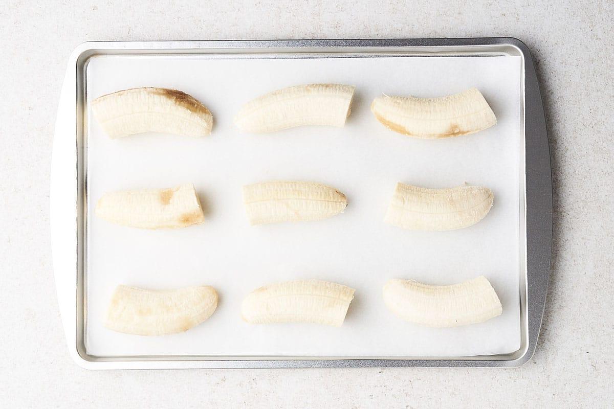 Bananen in Stücke geschnitten auf einem mit Backpapier ausgelegten Backblech einfrieren.