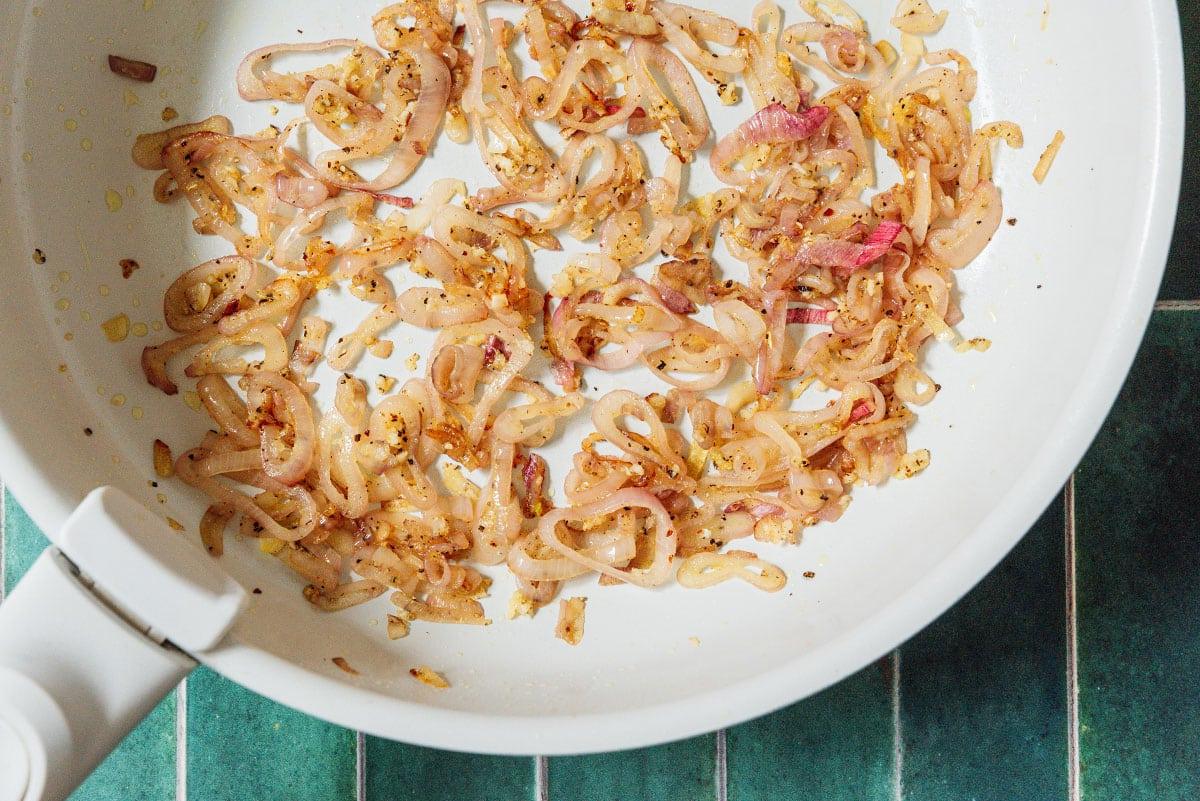Schalotten und Knoblauch in einer Pfanne anbraten.