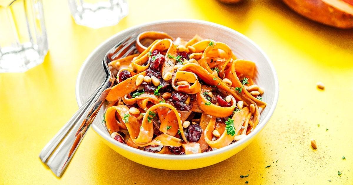 Süßkartoffel-Fettuccine-Nudeln in einer Schüssel auf gelbem Hintergrund