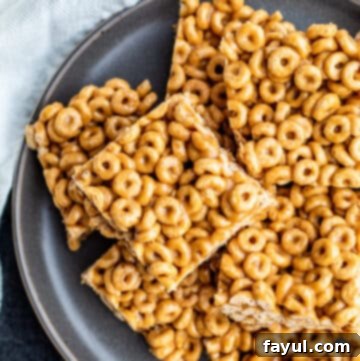 Golden brown no-bake Peanut Butter Cheerio Bars on a grey plate.
