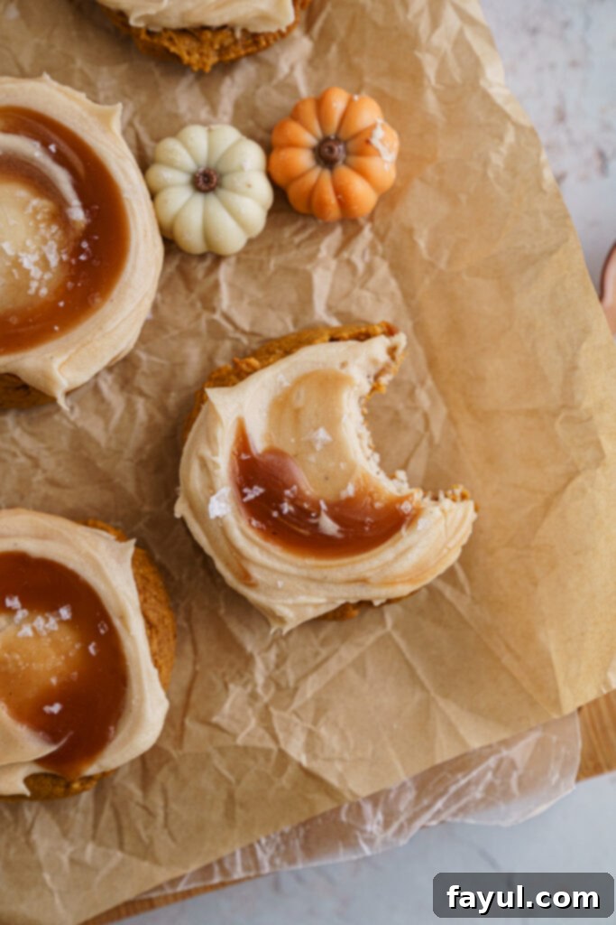 Freshly baked Pumpkin Caramel Cookies with frosting and caramel swirl on a cooling rack