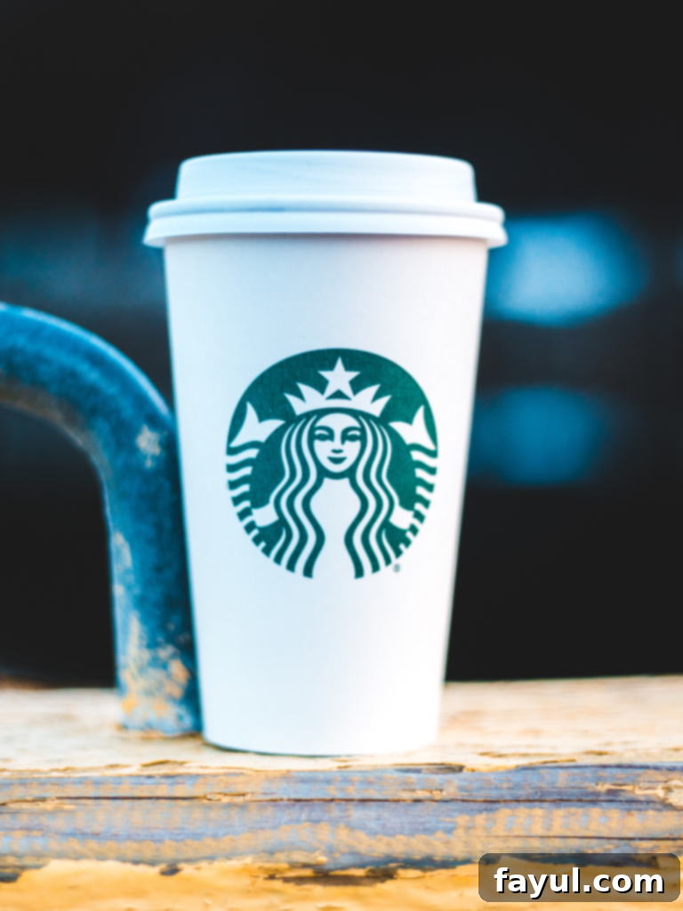A warm London Fog Tea Latte in a Starbucks mug, garnished with foamed milk.