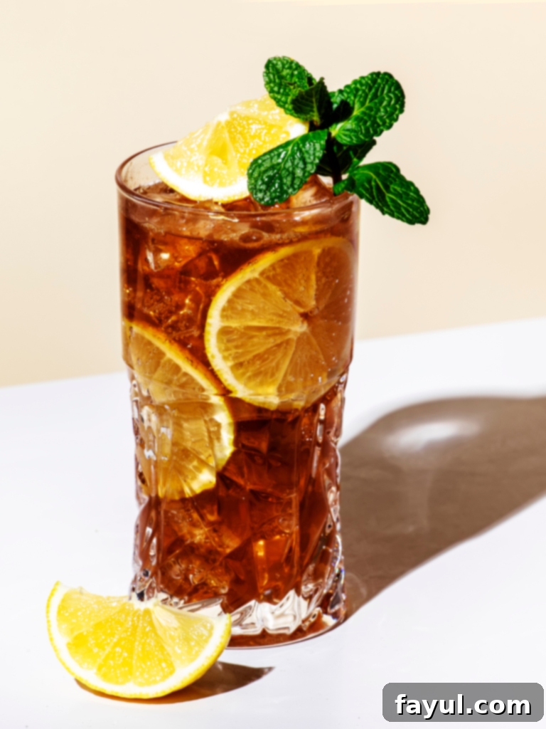 A tall glass of Iced Black Tea Lemonade with ice and a lemon slice.