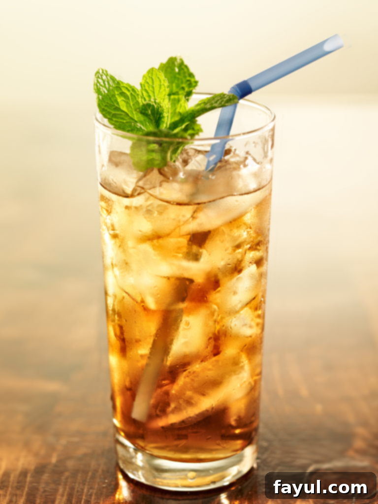 A clear glass of Iced Green Tea with ice and a subtle green hue.