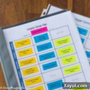 Overhead shot of a weekly dinner plan in a laminated folder, showing a fully organized meal schedule.