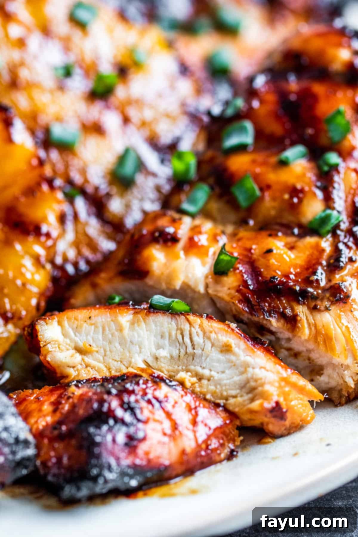 Sliced grilled Hawaiian BBQ chicken on a platter with caramelized pineapple slices, ready to be served.
