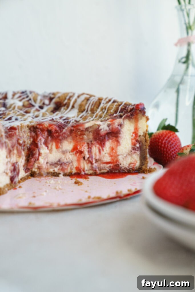 A beautifully baked Roasted Strawberry Crumble Cheesecake, golden brown on top with visible strawberry swirls.