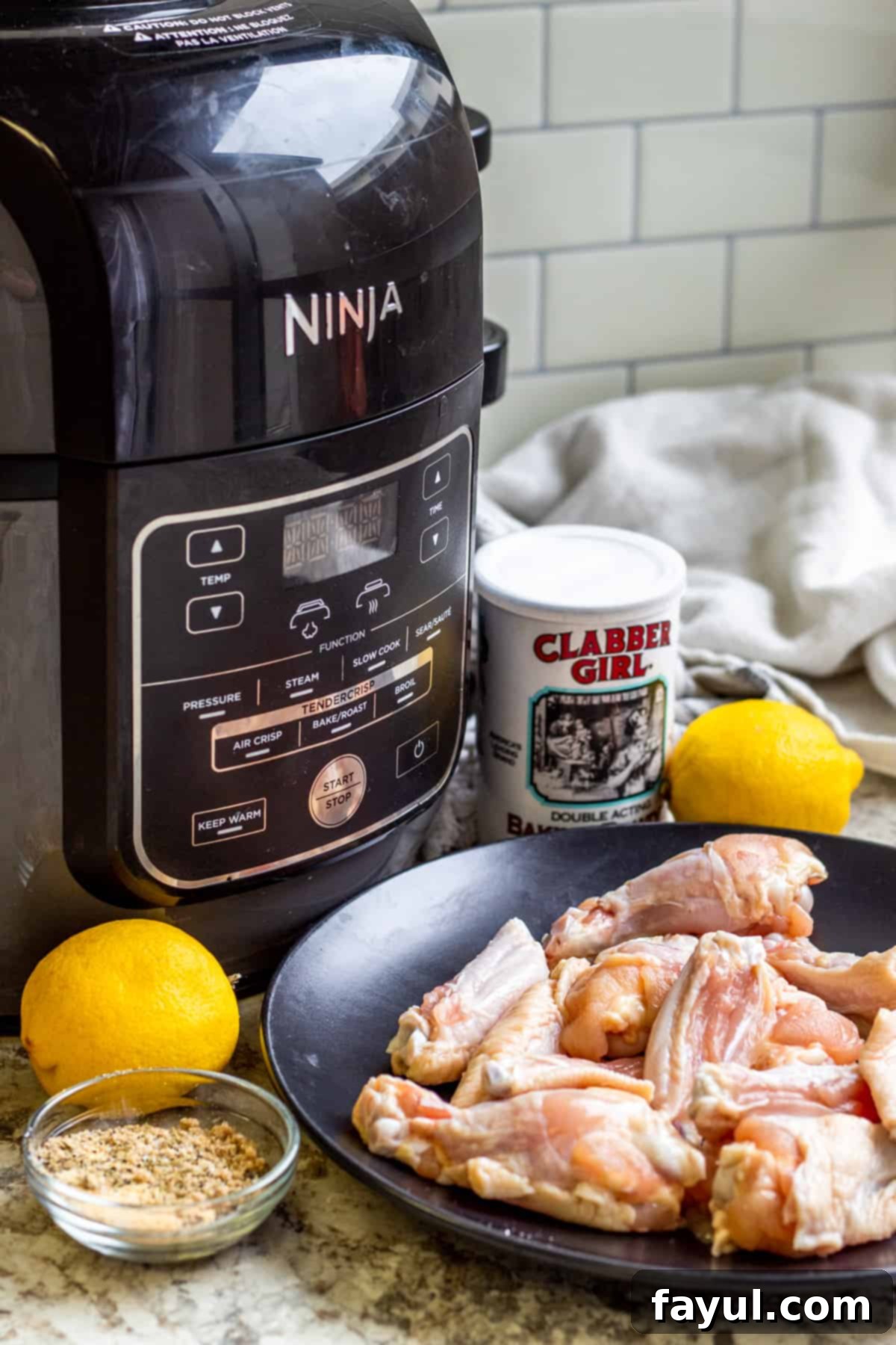 Crispy Air Fryer Lemon Pepper Chicken Wings 3 Chicken wing ingredients laid out on white counter next to air fryer.