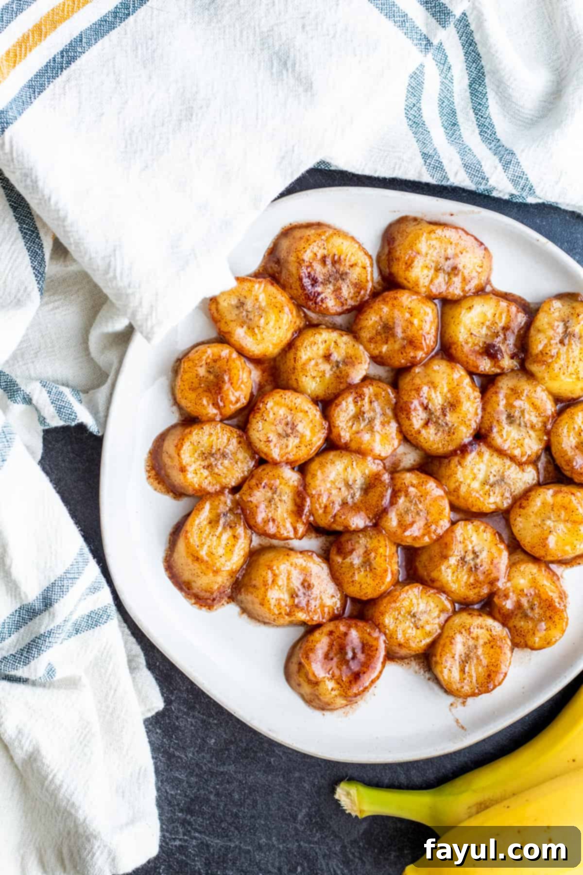 Overhead shot of fried bananas on white plate.