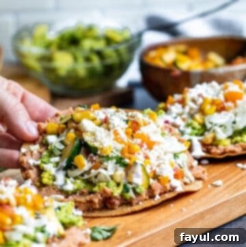 Crispy Vegetarian Tostadas with Bright Cilantro Lime Slaw 11 Hand picking up tostada off of cutting board.