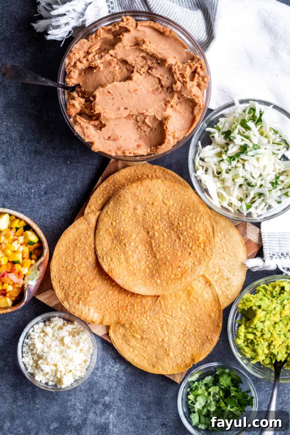 Crispy Vegetarian Tostadas with Bright Cilantro Lime Slaw 7 Overhead shot of all ingredients laid out on blue table for assembly.