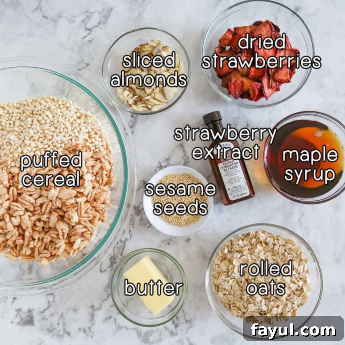 Double Strawberry Granola Delight 3 Overhead shot of all the dry and wet ingredients laid out neatly for making strawberry granola: dried strawberries, sliced almonds, various puffed cereals, strawberry extract, maple syrup, sesame seeds, butter, and rolled oats.
