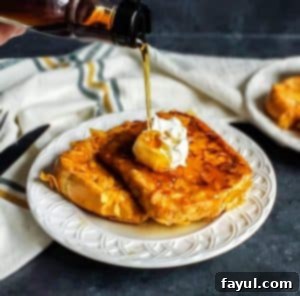 French toast on a white plate with syrup being poured on top. The golden-brown toast is topped with a dollop of whipped cream, making it an enticing treat for breakfast or brunch.