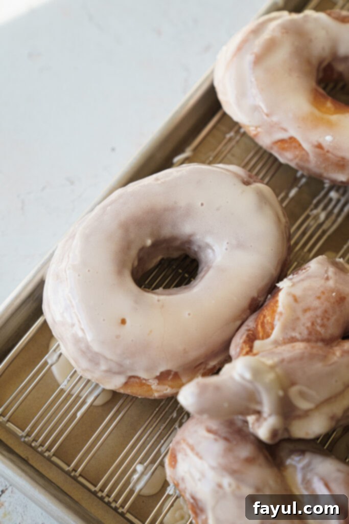 Raw brioche donut dough being stretched to show the windowpane test