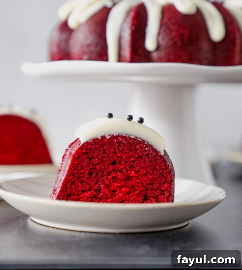 Beautifully decorated Red Velvet Bundt Cake ready to be served, topped with cream cheese frosting and chocolate shavings.
