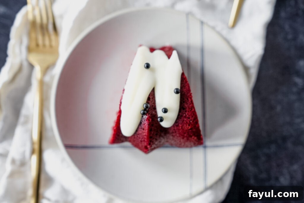 Sliced Red Velvet Bundt Cake revealing a generous layer of tangy cream cheese frosting.
