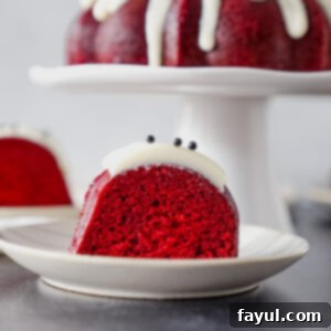A slice of Red Velvet Bundt Cake with cream cheese frosting and chocolate curls